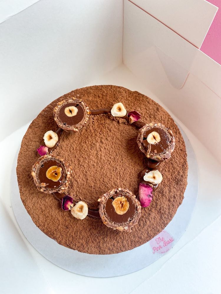 Nutella and Rocher mousse entremet dusted with cocoa, topped with Ferrero Rocher halves