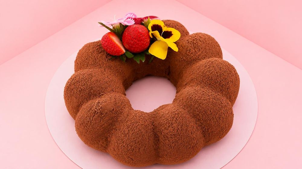 Truffolo — cocoa-dusted chocolate mousse cake crowned with strawberries and edible flowers